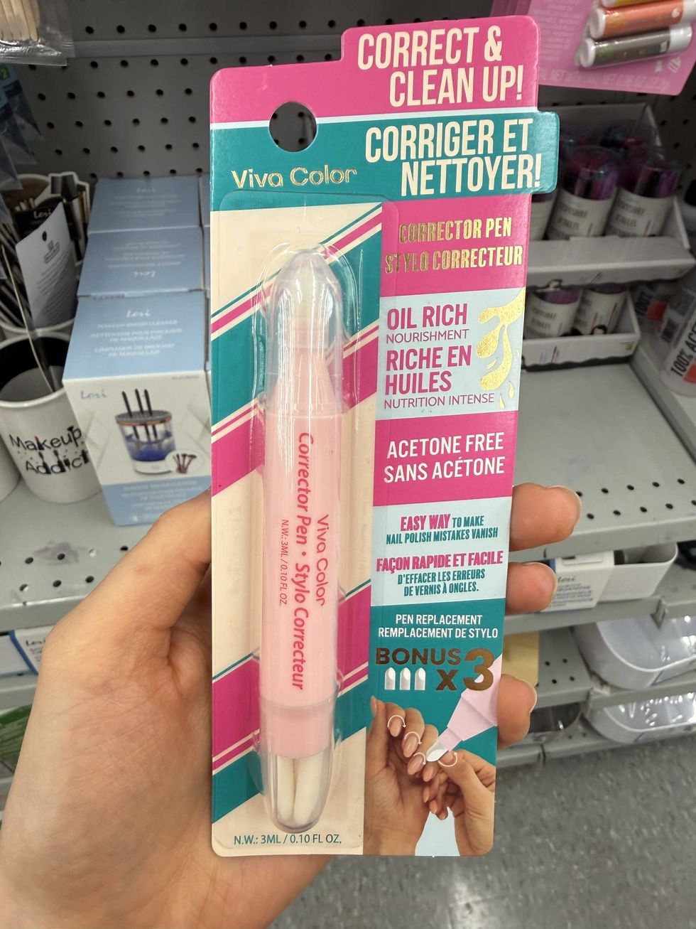 A pink tube with a label that reads "corrector pen" and shows it being used on nails.