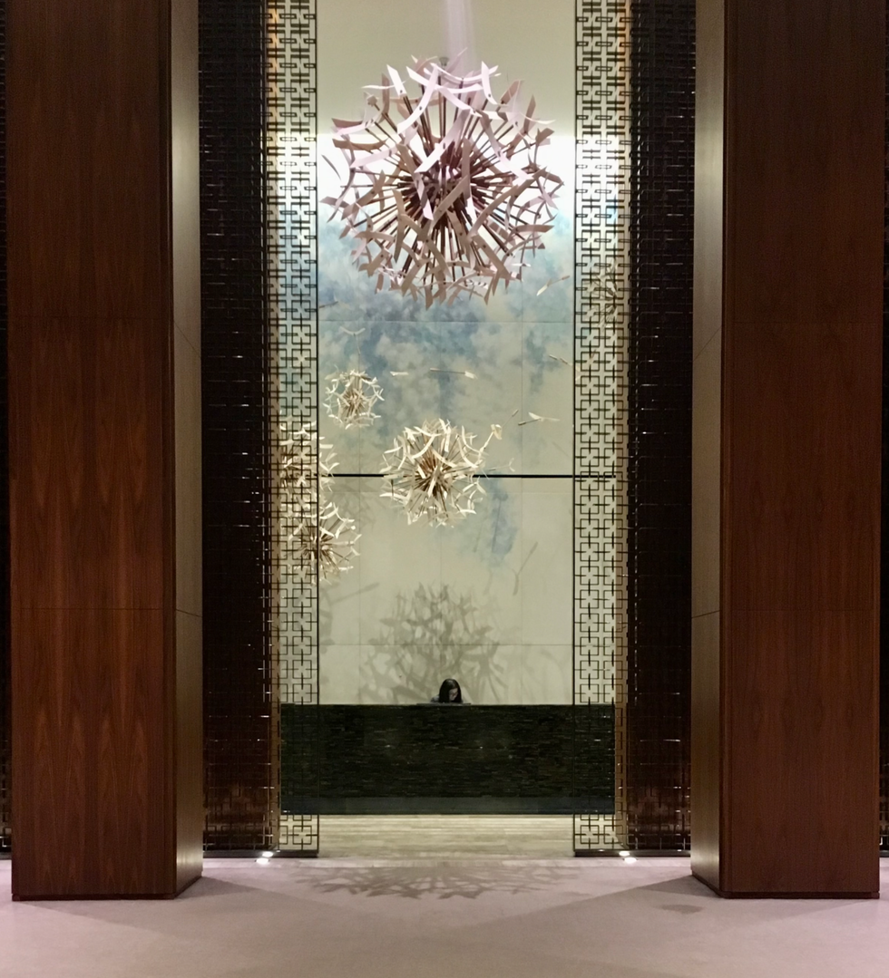 A reception desk in a vast, high-ceilinged hotel lobby.