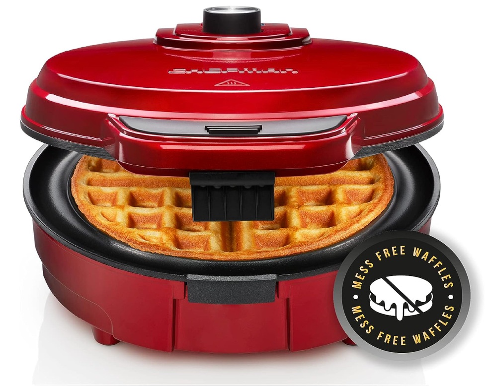 A red waffle maker with a waffle on it.