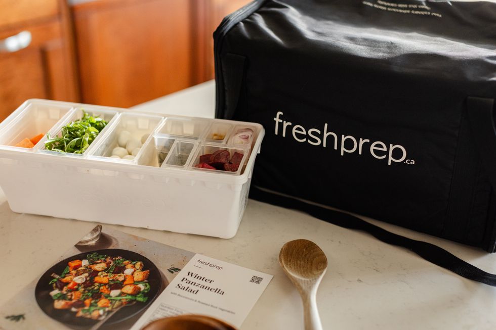A resusable cooler bag sits on a counter next to a recipe card and ingredients to make a Fresh Prep Meal.