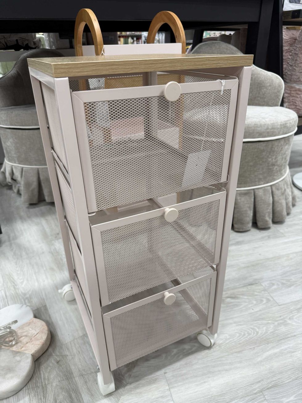 A rolling cabinet with three drawers and on wheels.