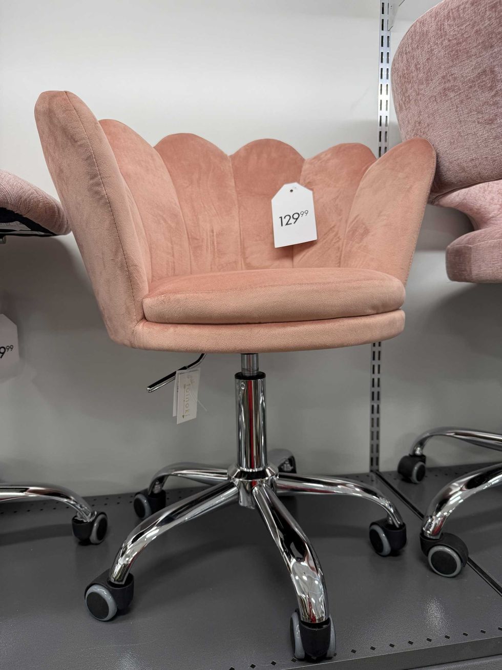 A rolling desk chair with a pink cushion.
