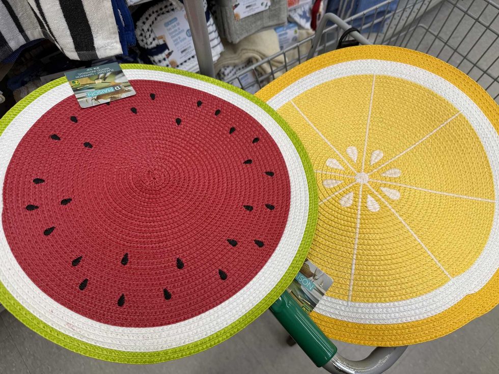 A round placemat with a watermelon design on it next to a yellow one that has a lemon design on it.