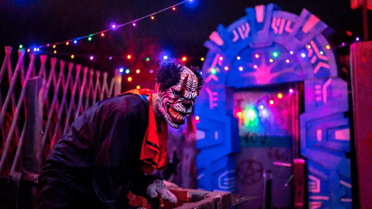 A scary clown at a haunted attraction.