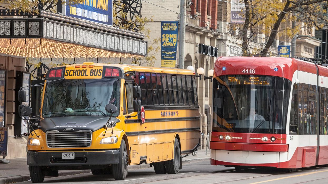 A school travelling alongside a TTC streetcar.