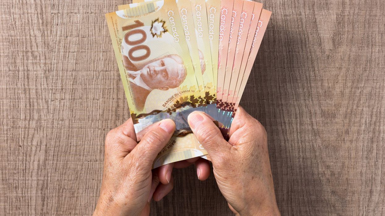 A senior holding Canadian cash.