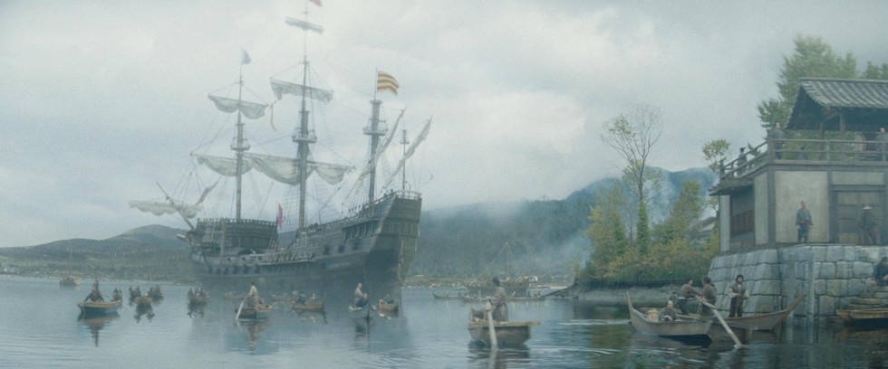 A ship and smaller boats in the water.