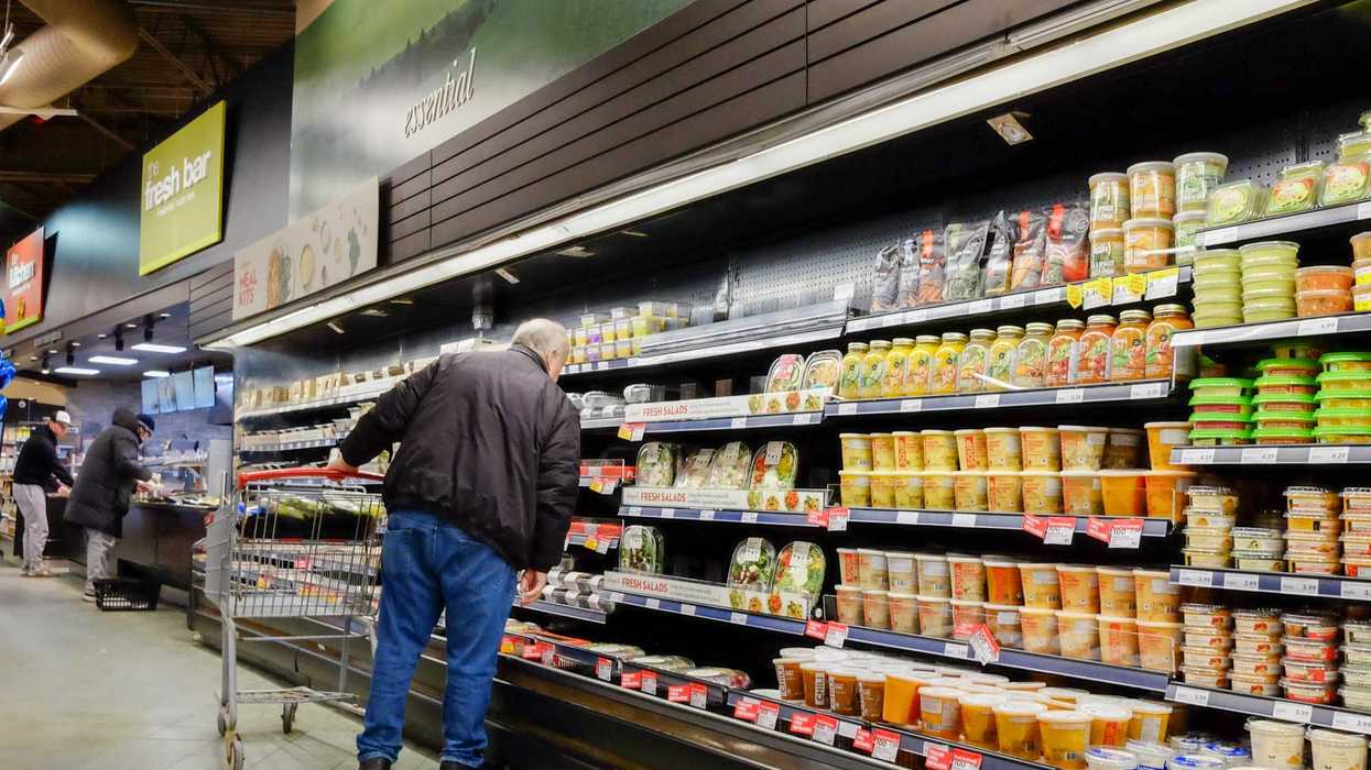 A shopper looks at price tags at a grocery store in Canada.
