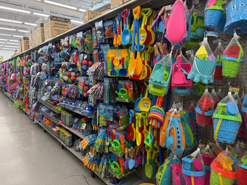 A shopping aisle inside of a store filled with colourful beach toys for kids.