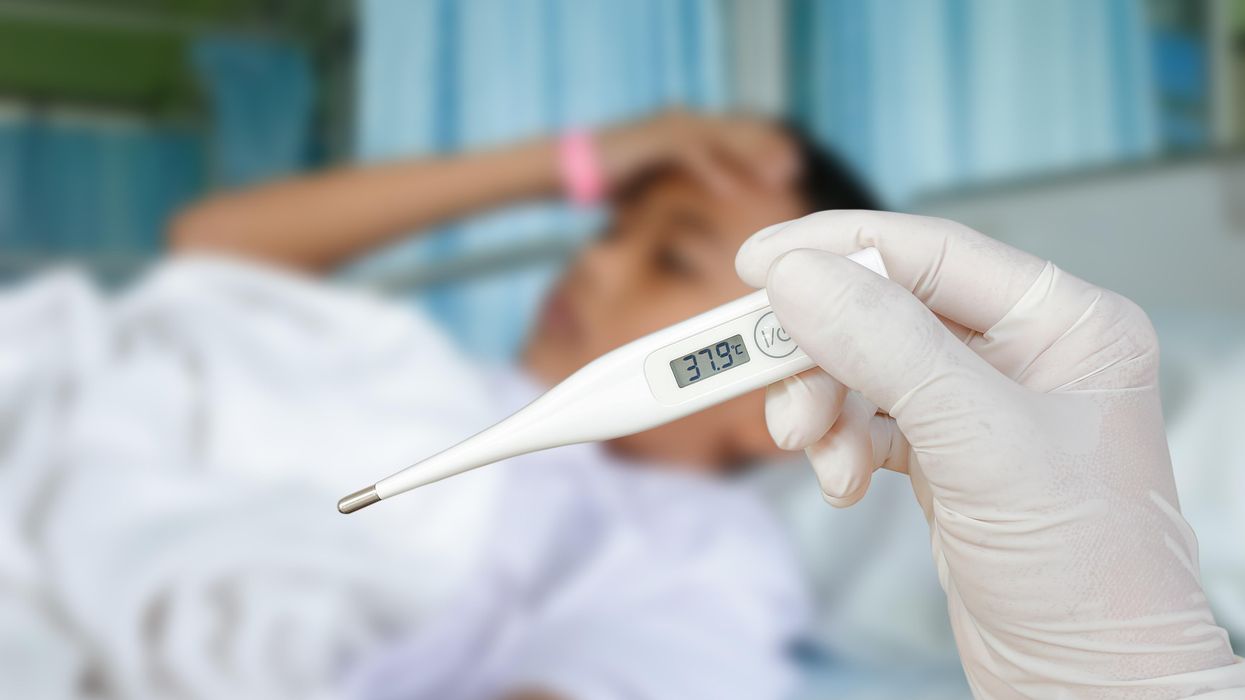 A sick boy at the hospital getting his temperature checked.