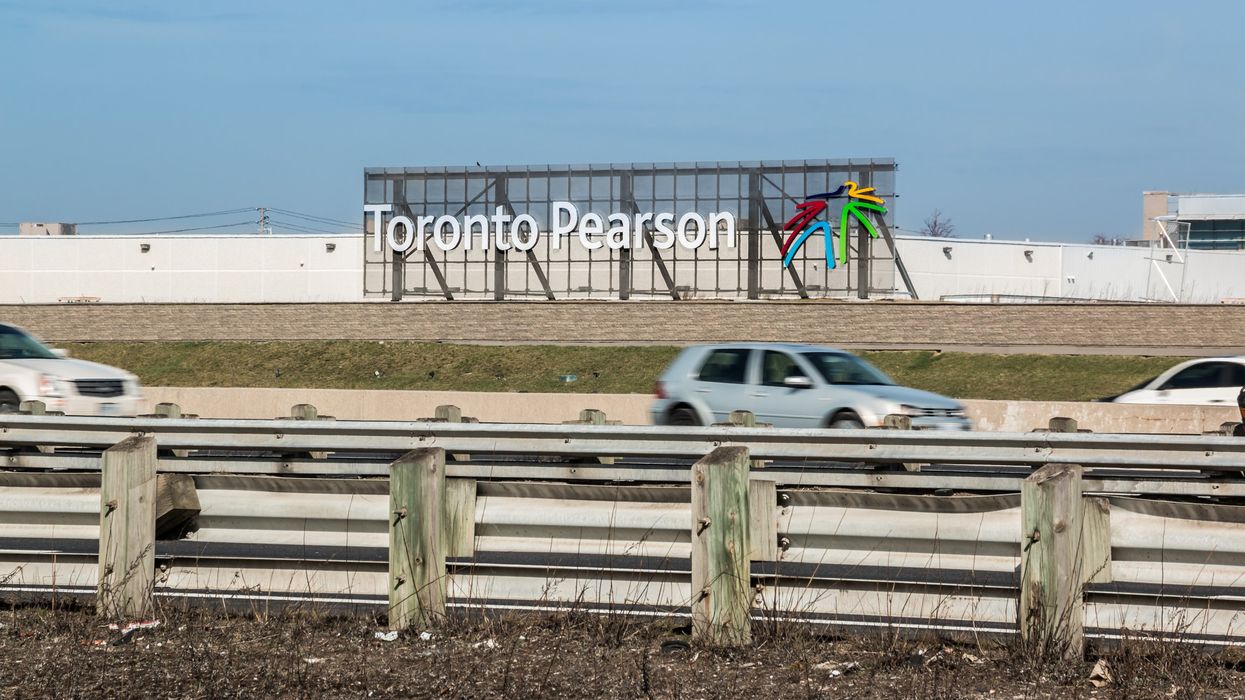 A sign for Toronto Pearson Airport as cars drive down Highway 401.