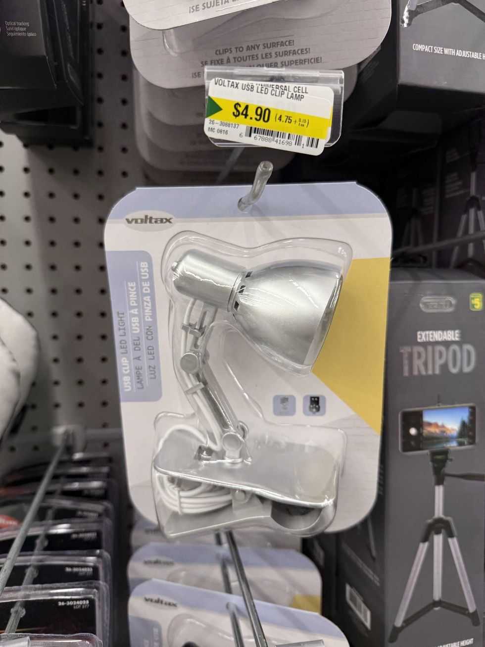A small silver lamp hanging on a store shelf with a label that reads USB clip LED light.