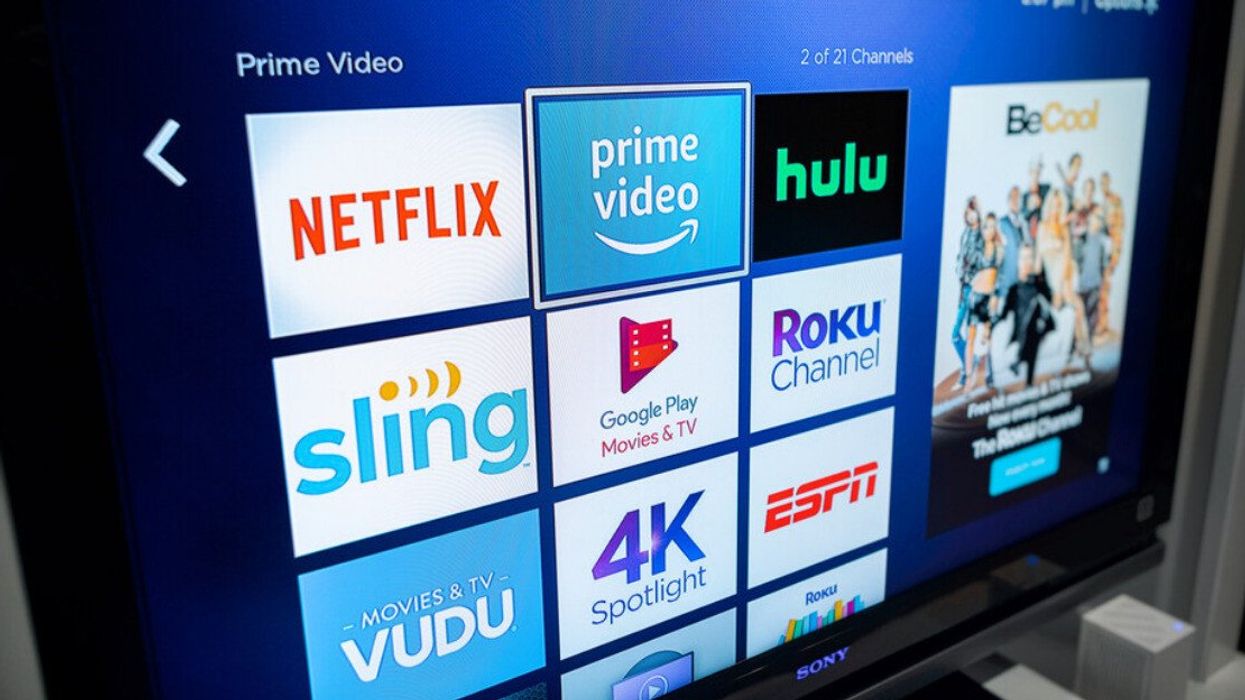 A smart TV with streaming platforms displayed.