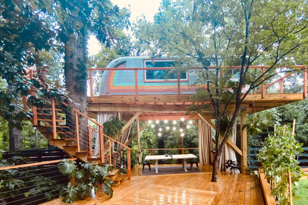 A spiral staircase leads down from the airstream treehouse to the outdoor deck.