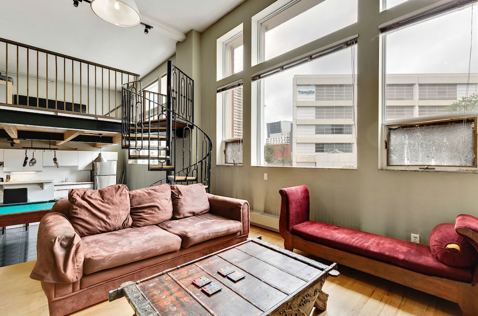 A spiral staircase leads from the living room to the bedroom.