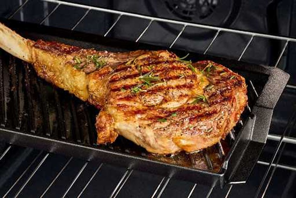 A steak on a grill plate in an oven.