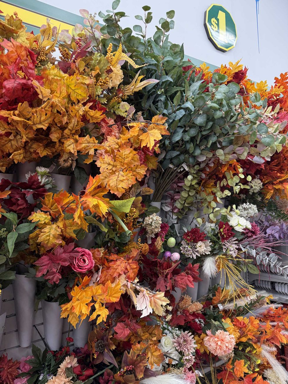 A store wall filled with faux flowers in various colours.