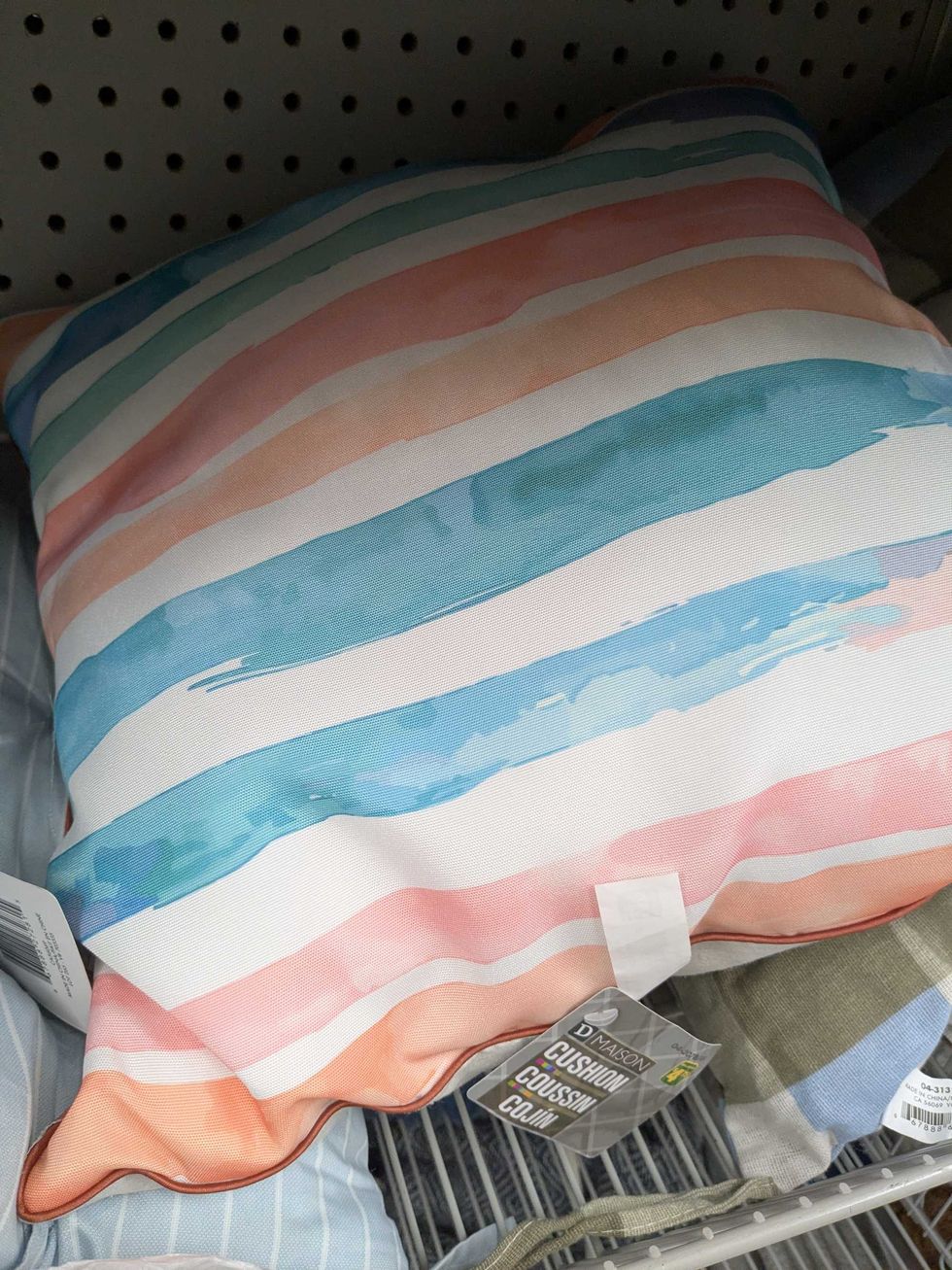 A striped colourful cushion on a shelf
