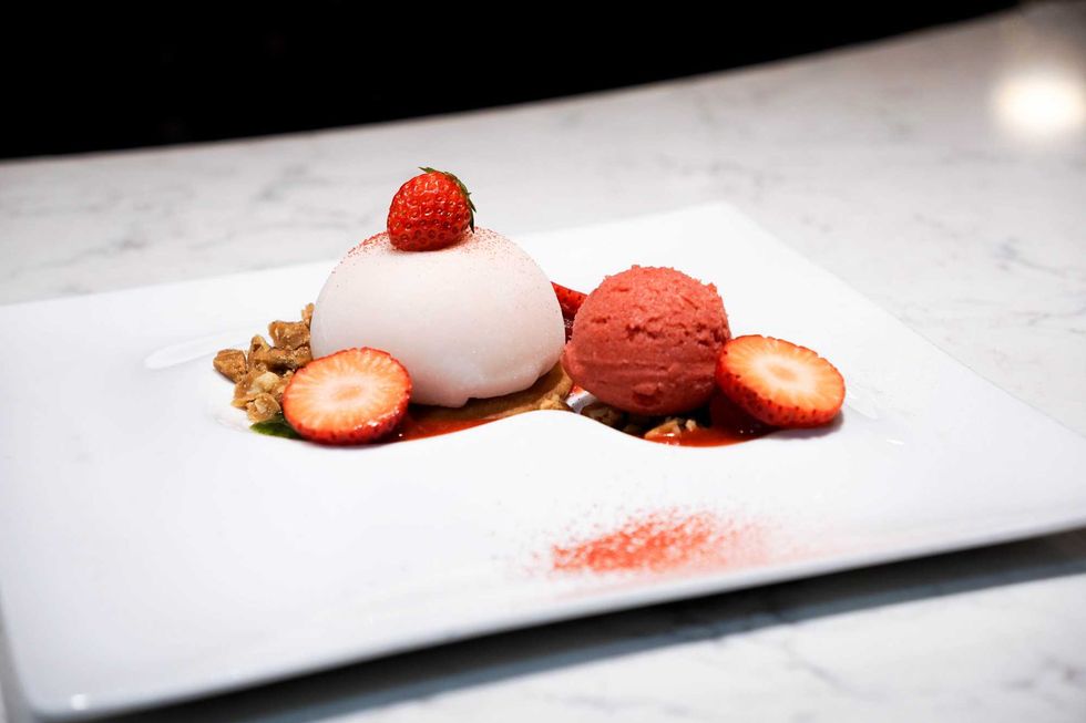 A stuffed mochi dessert with fresh strawberries and walnut toffee.