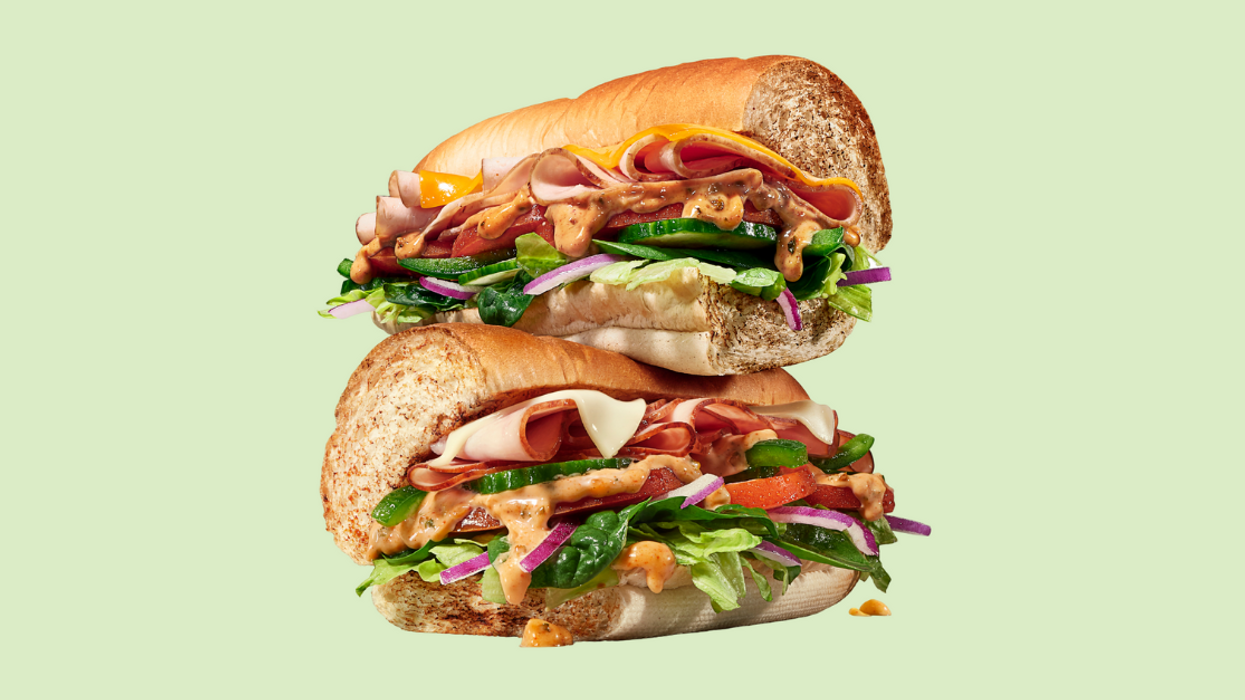 A Subway sandwich made with the new Mojo sauce on a green background.