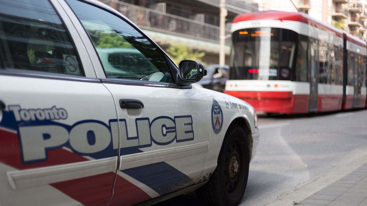 A Toronto police car in the street with a TTC streetcar in the background.