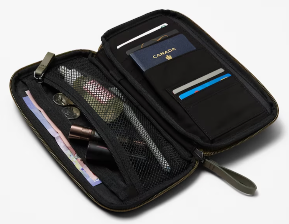 A travel wallet filled with money, credit cards, a passport and other travel essentials.