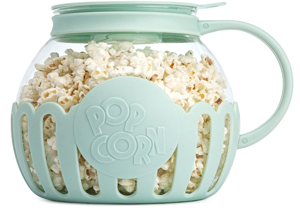 A turquoise microwave popcorn popper filled with popcorn.