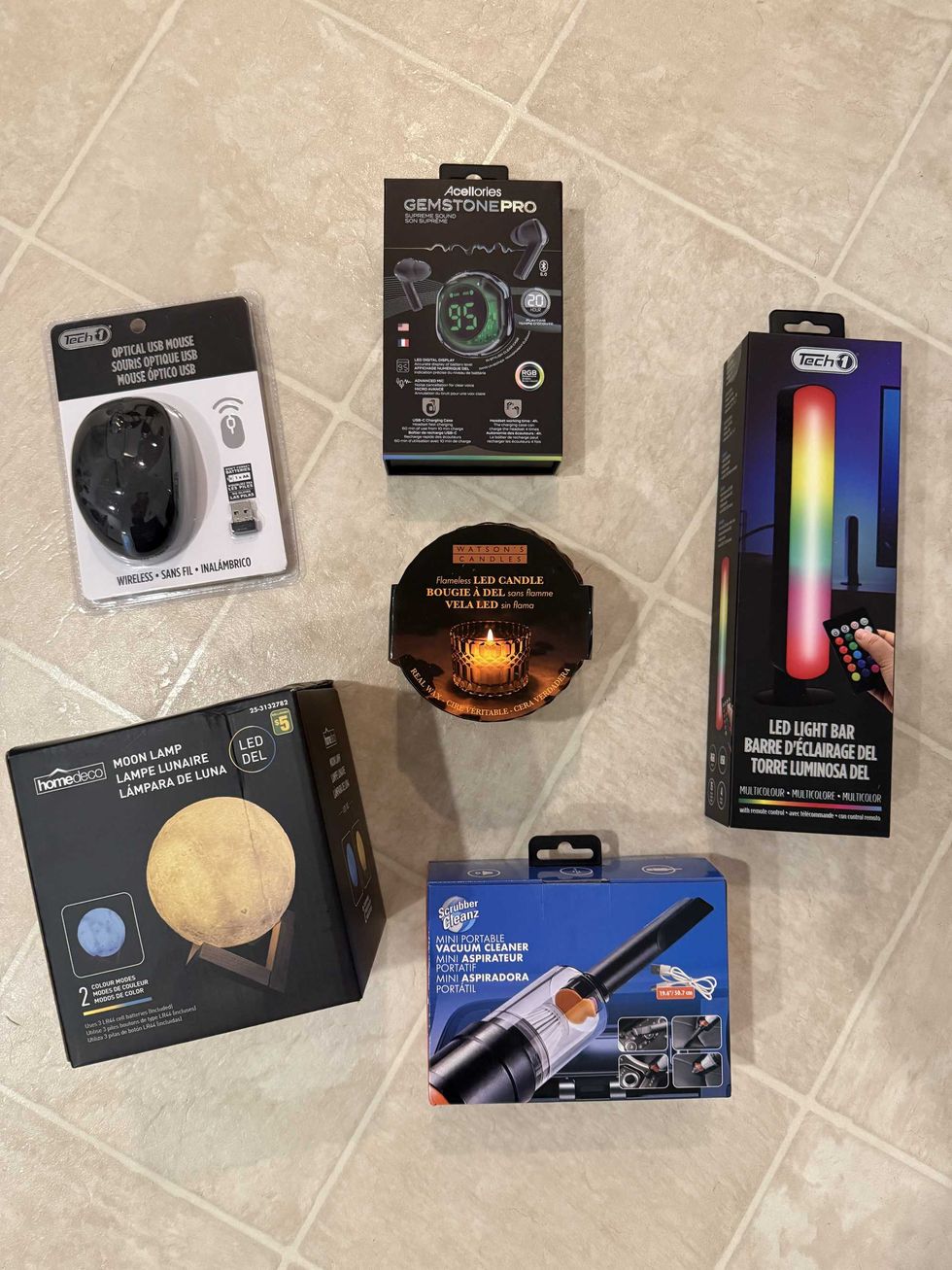 A variety of Dollarama products, including a moon lamp, USB mouse, headphones, an LED light bar, a mini portable vacuum cleaner and a flameless LED candle.