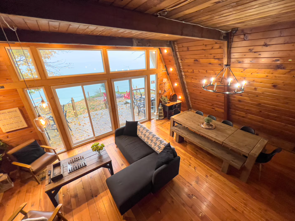 A view of a living room is shown, with a window providing views of the lake.