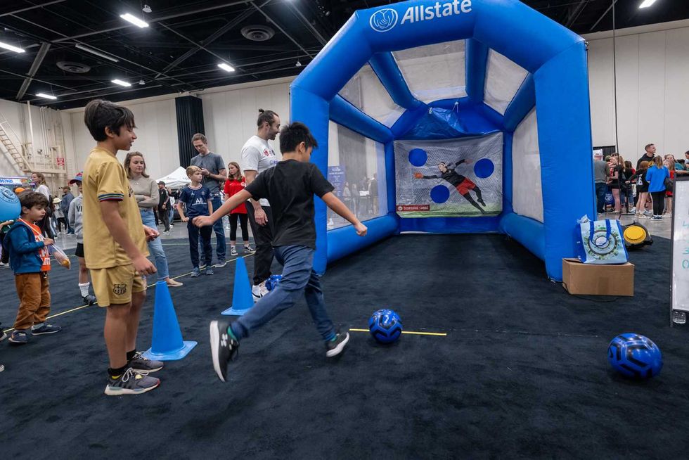 A visitor kicks a soccer ball at the Allstate Soccer Show