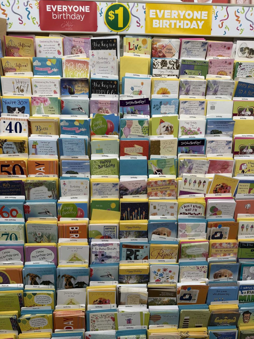 A wall full of birthday cards inside a store.