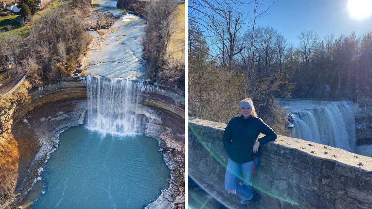 A waterfall. A person standing by a waterfall.