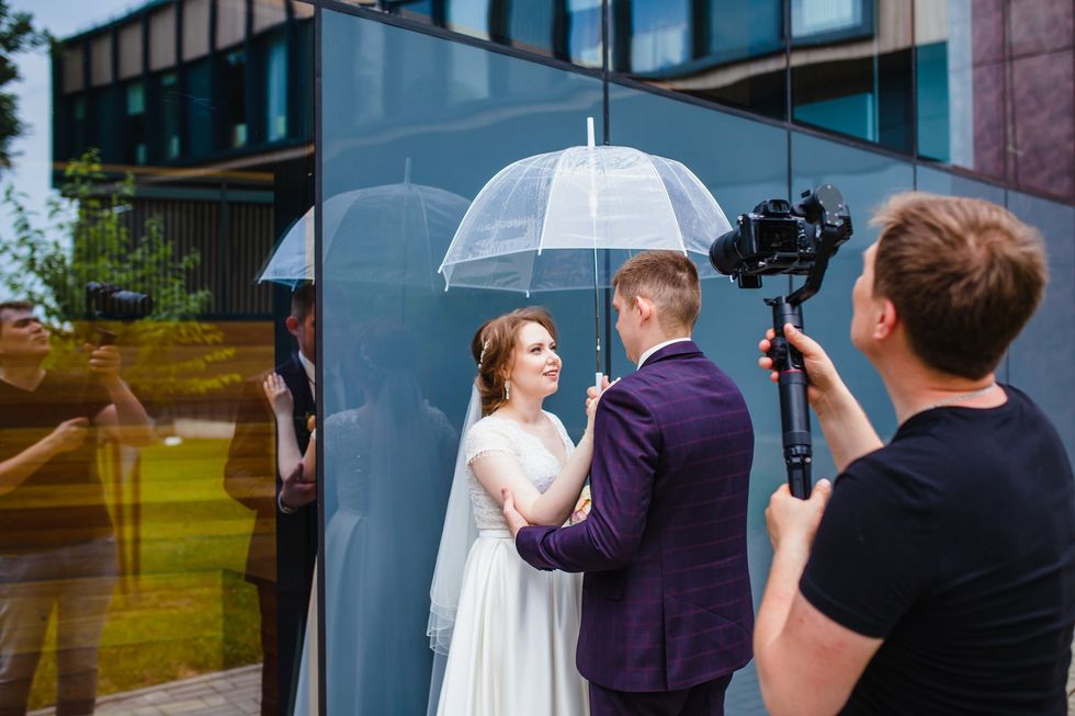 A wedding videographer filming newlyweds on their wedding day.