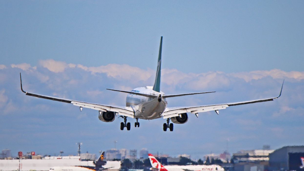 A WestJet Boeing 737-700 lands at Toronto Pearson International Airport.