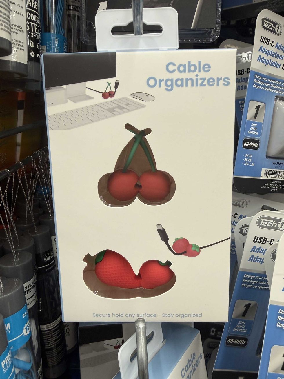 A white and blue box with a photo of a computer and two cable holders in the shapes of strawberries and cherries.