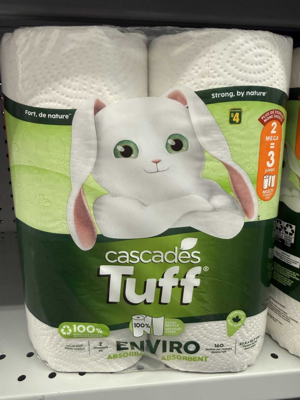 A white and green bag with paper towel rolls in it with a white bunny on the front.