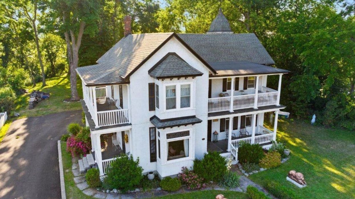A white house with upper level porches.