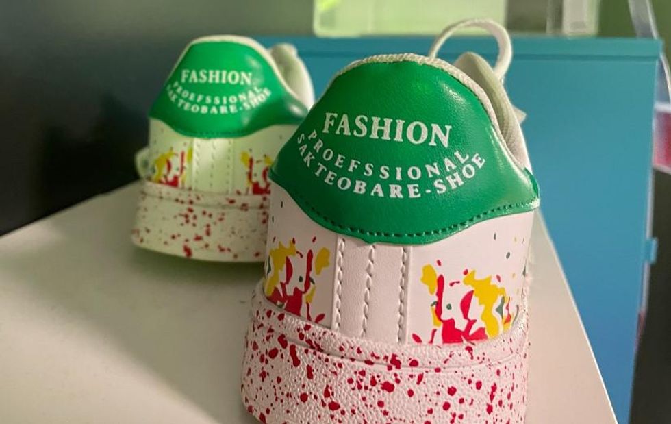A white paint splatter shoe labeled Fashion Proefssional Sakteobare-Shoe.