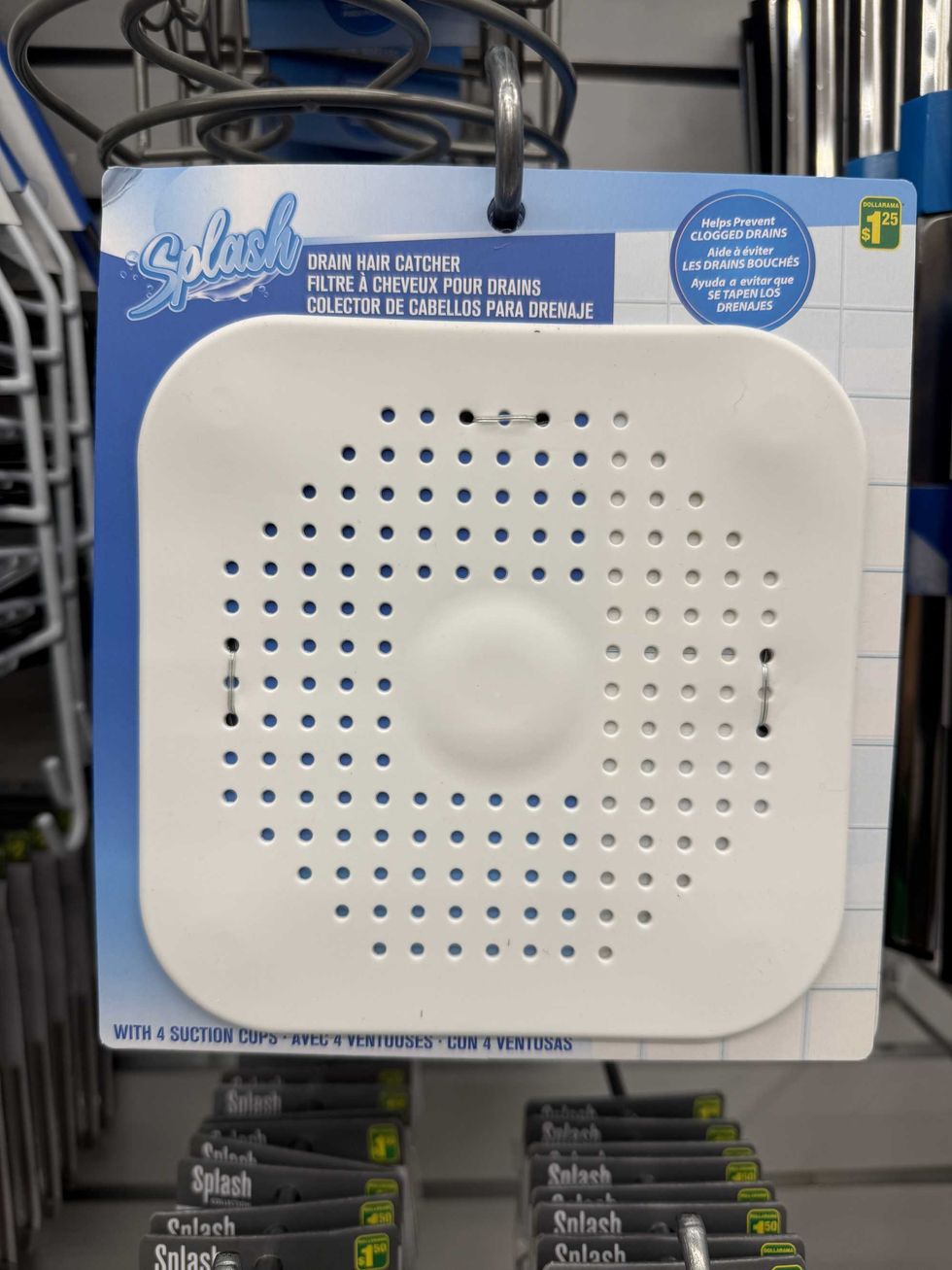 A white plastic square with small holes in it and the label reads drain hair catcher.
