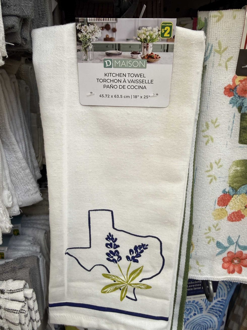 A white towel with a blue and green design on the bottom.