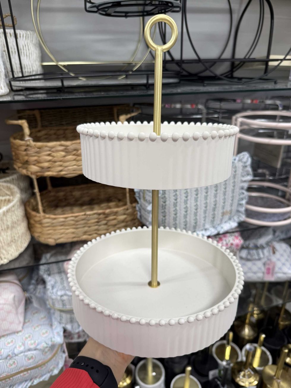 A white two-tiered tray with gold accents.