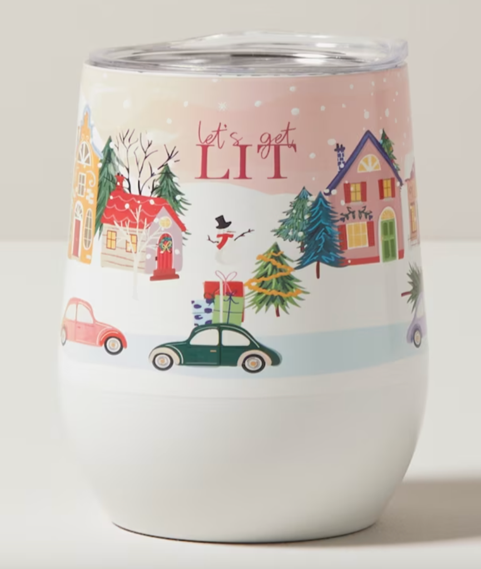 A wine tumbler that says "Let's Get Lit" and has houses, cars with presents on top of them and snow.