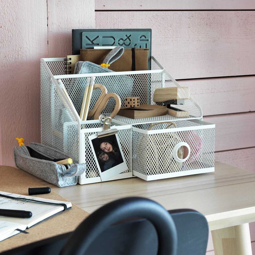 A wire desk organizer with multiple compartments on a desk.