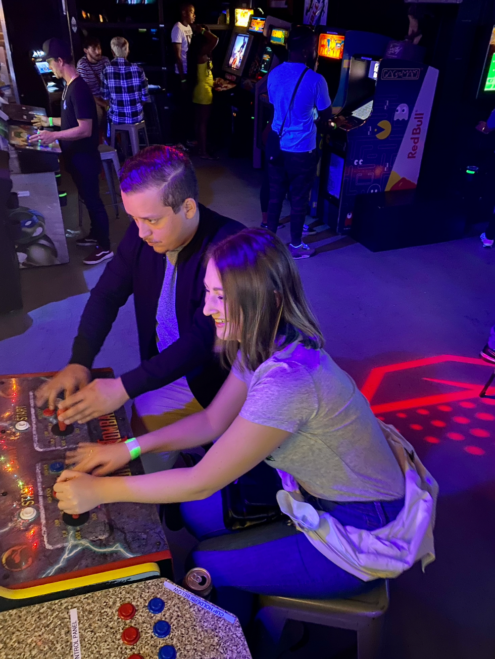 A woman and a man playing an arcade game.
