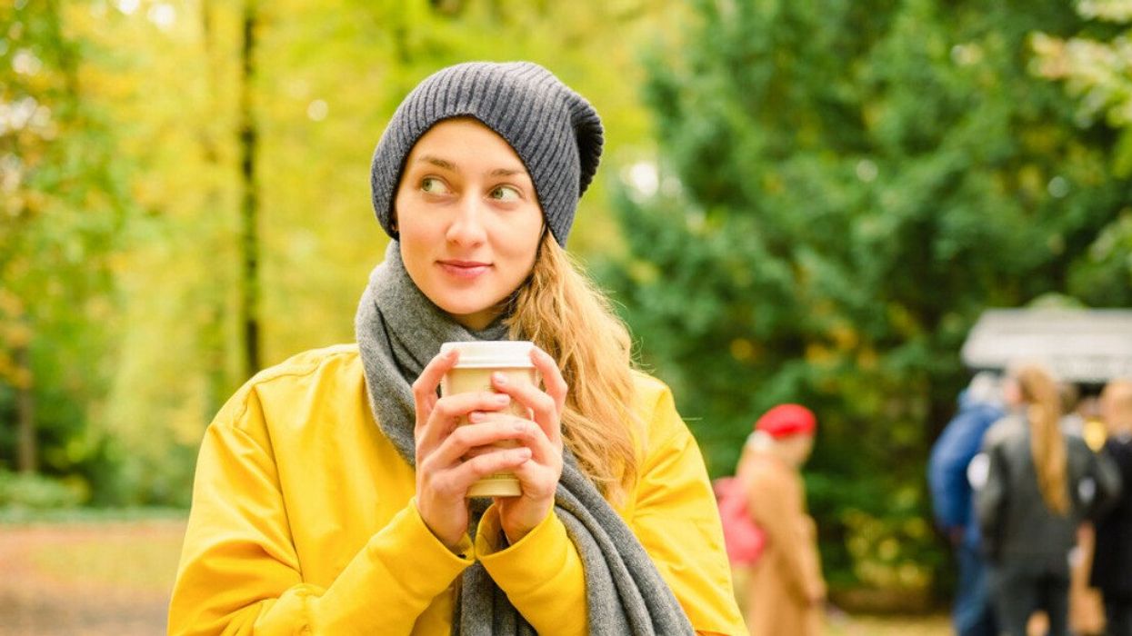 A woman enjoying a fall drink.
