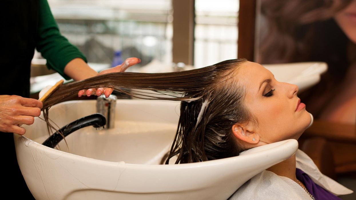 A woman getting her hair treated at a salon.