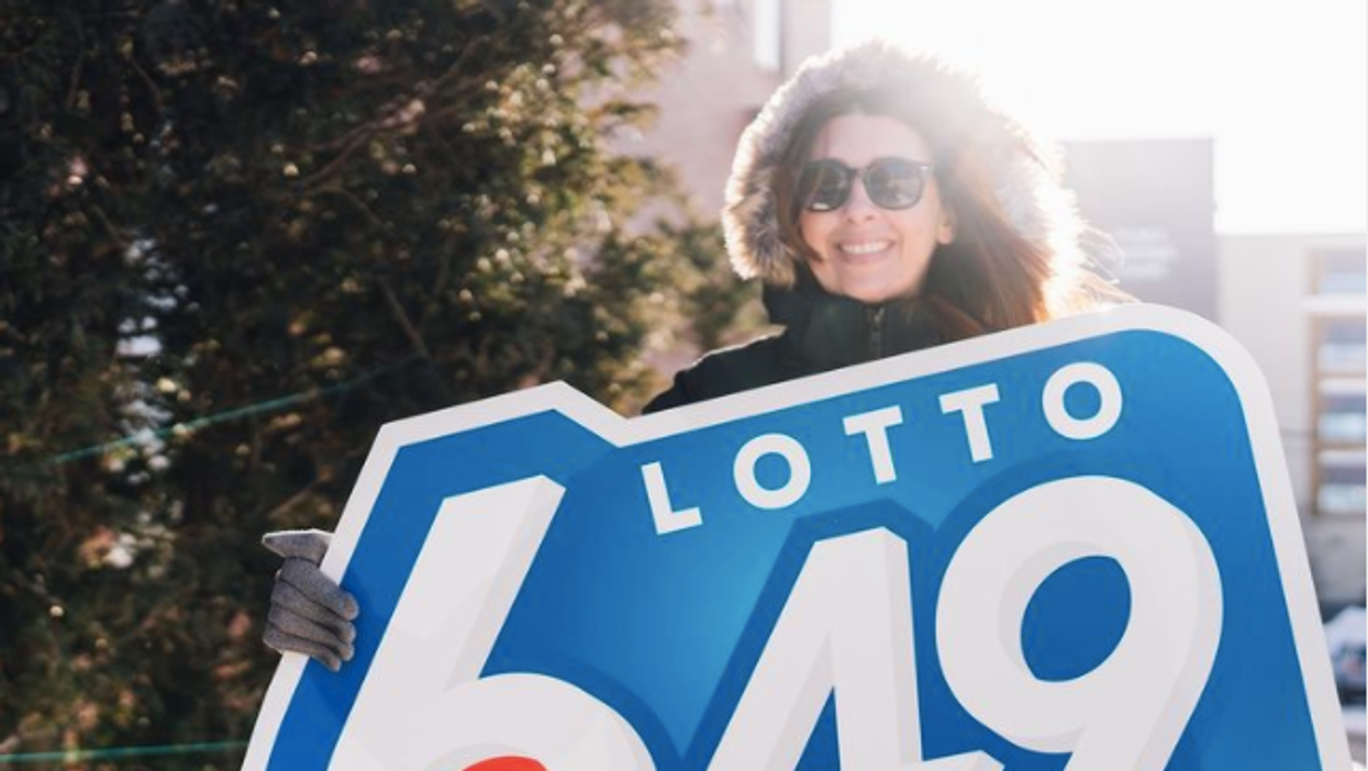 A woman holding a Lotto 6/49 sign.