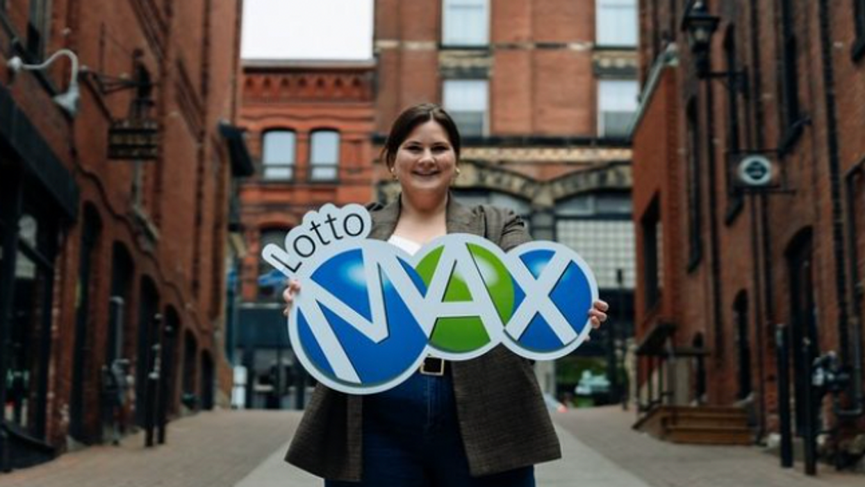 A woman holding a Lotto Max sign.