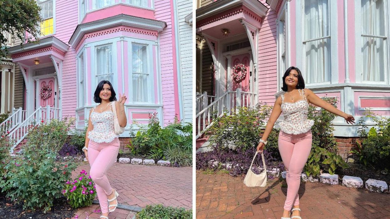 A woman in front of the pink Airbnb in Savannah.