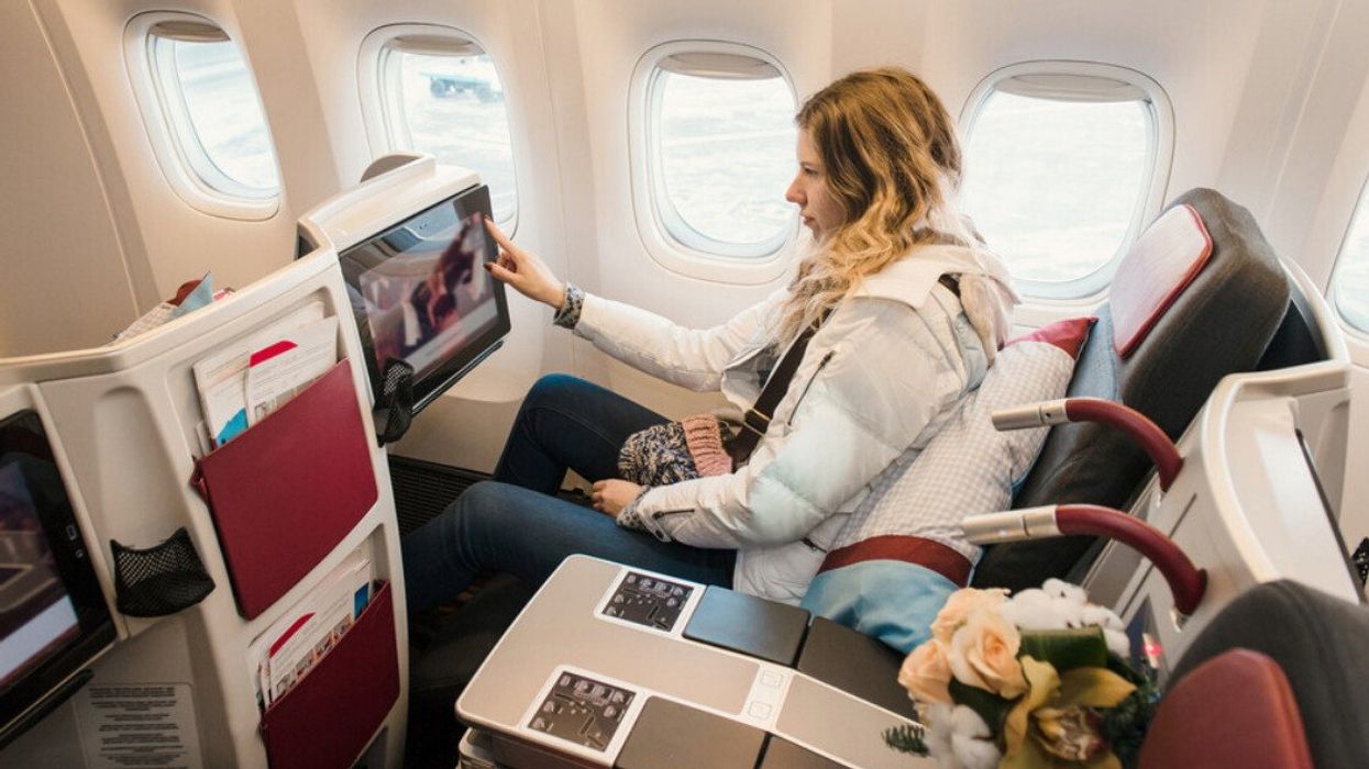 A woman is shown in first class on a plane.